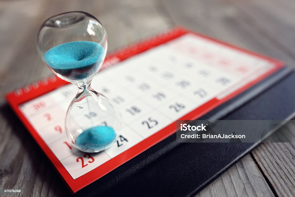 Hourglass on calendar Hour glass on calendar concept for time slipping away for important appointment date, schedule and deadline Calendar Stock Photo