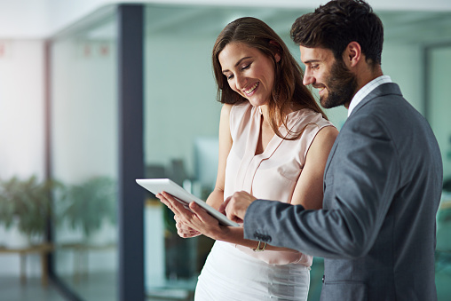 Shot of a young businessman and businesswoman using a digital tablet together in an office