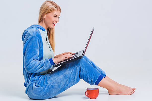 istock girl in pajamas with a laptop 611077532