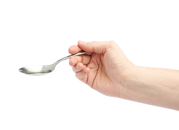 istock Male hand holding a spoon with oil 611078594