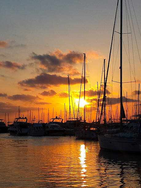 istock Sailing ships in port at sunset with red sky 611083516