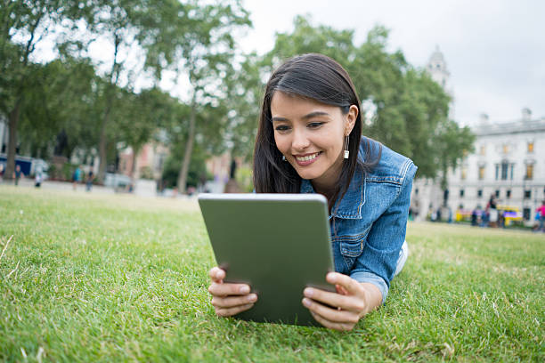istock Woman using a tablet at the park 611084222