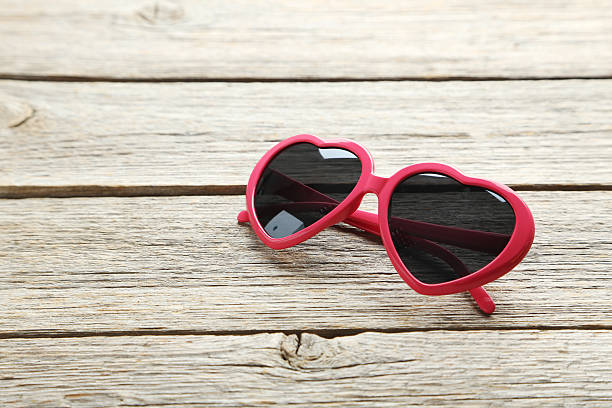 istock Pink sunglasses on grey wooden table 611085320