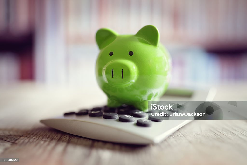 Piggy bank with calculator Piggy bank on calculator concept for saving, accounting, banking and business account Green Color Stock Photo