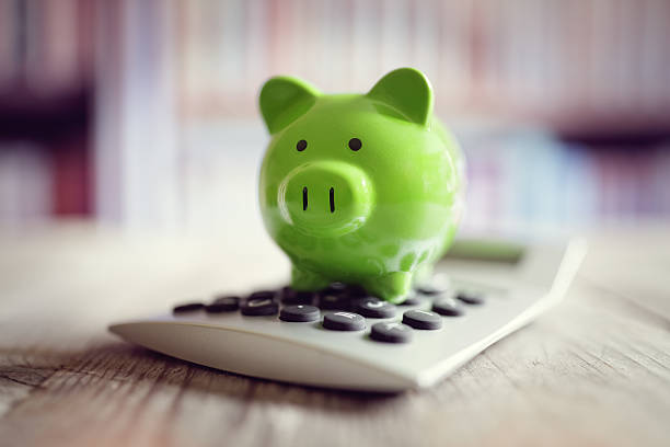 Piggy bank with calculator Piggy bank on calculator concept for saving, accounting, banking and business account home finances stock pictures, royalty-free photos & images