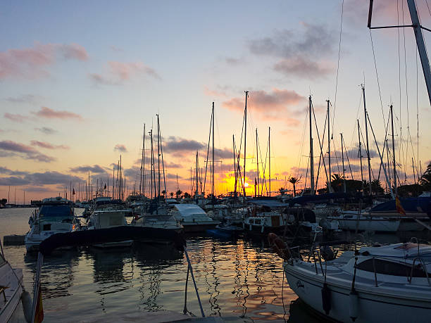 istock Sailing ships in port at sunset with red sky 611087328