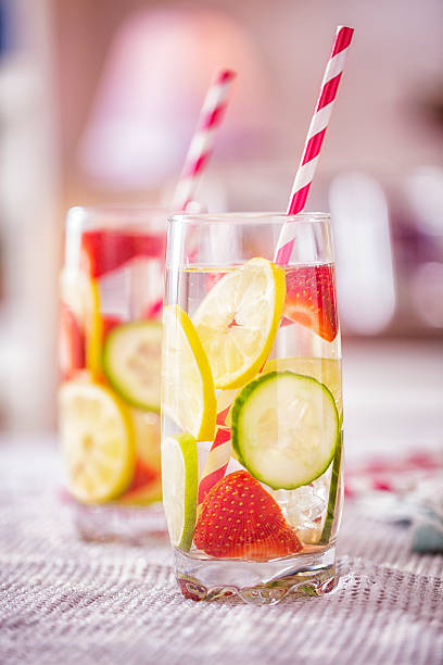 Infused Water with Fresh Strawberries, Lime, Lemon and Basil Infused water with fresh strawberries, lime, lemon and basil served in a glass. lime basil plant stock pictures, royalty-free photos & images