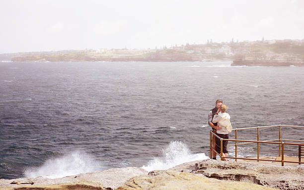 istock Couple on lookout, big waves hitting rock 611089834