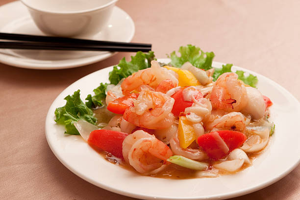 istock Fried lily shrimp with tomato and lettuce on white plate 611090854