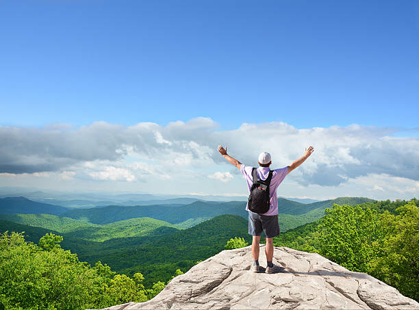 istock Happy man  with raised hands on top of the mountain 611094514