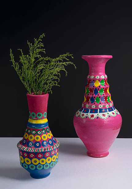 istock Pink handcrafted pottery vases and green branches with harsh shadow 611094534