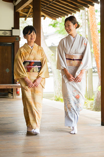 Japanese Women at the Temple Two Japanese women wearing kimono, walking at a Buddhist temple. Taken on location in Kyoto, Japan. kimono stock pictures, royalty-free photos & images