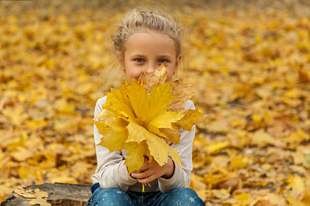 istock Girl in autumn leaves 611097644