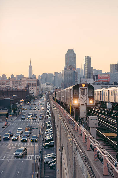 el tren del metro de nueva york conduce hacia queens durante la puesta del sol en hora punta - sunnyside fotografías e imágenes de stock