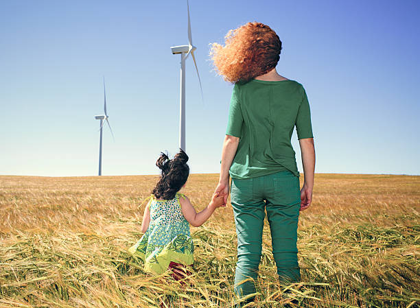 istock mother and child in cereal field with wind turbines 611099080