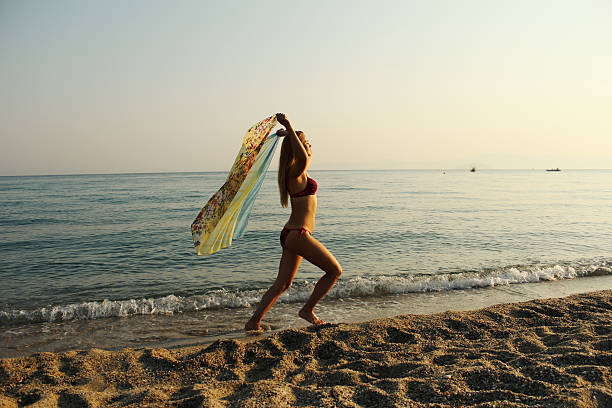 istock Happy free yonug woman running on beach 611100120