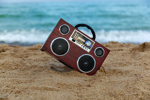 In the background of the radio recorder waves wash the shore,Radio recorder on the sand