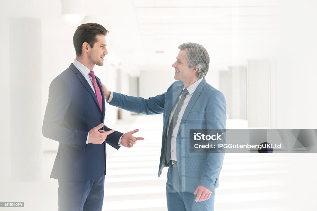 Businessmen having discussion in new office Hand On Shoulder Stock Photo