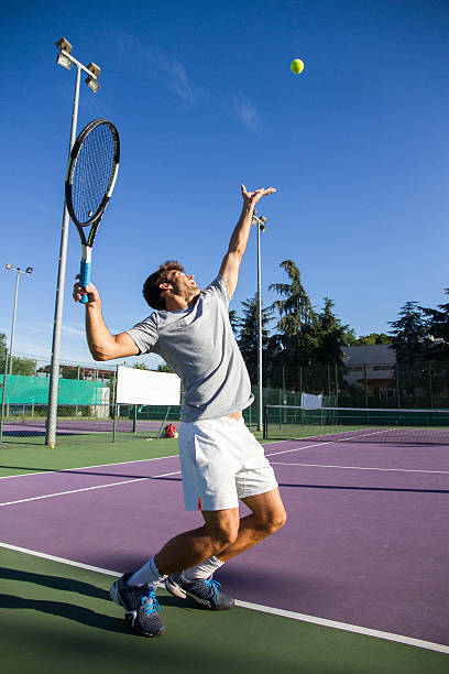 プロテニス選手はキックテニスをしています。 - tennis serving men court ストックフォトと画像