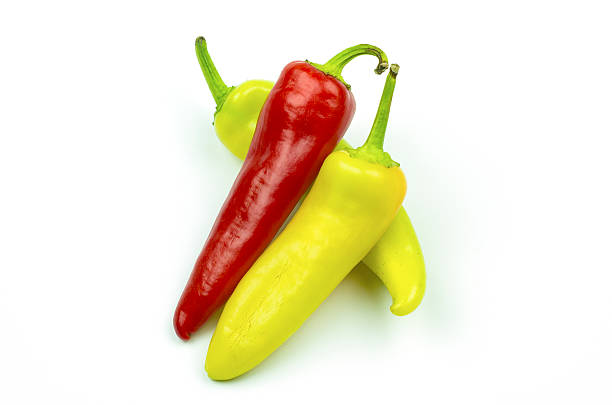 istock Three peppers of yellow, green, and red isolated on white 611105748