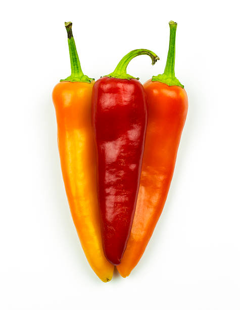 istock Three peppers of orange and red isolated on white 611105770
