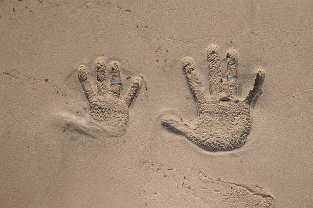 istock the hand prints in the sand with a wedding ring 611109412