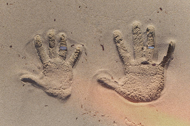 istock the hand prints in the sand with a wedding ring 611109426
