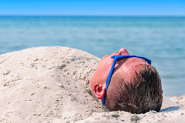 istock man buried in the sand 611110006