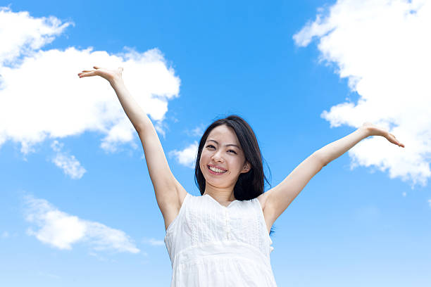 istock Japanese woman standing under a blue sky 611169570