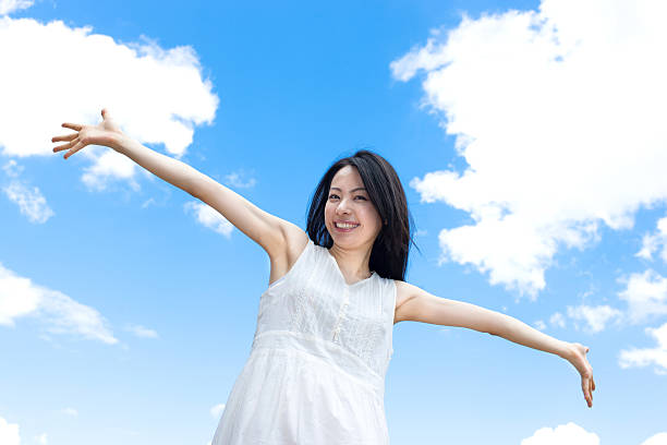 istock Japanese woman standing under a blue sky 611169586
