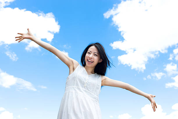 istock Japanese woman standing under a blue sky 611169610