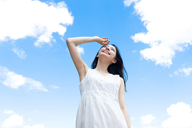 istock Japanese woman standing under a blue sky 611169630
