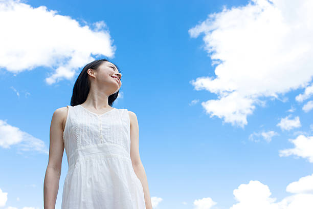 istock Japanese woman standing under a blue sky 611169682