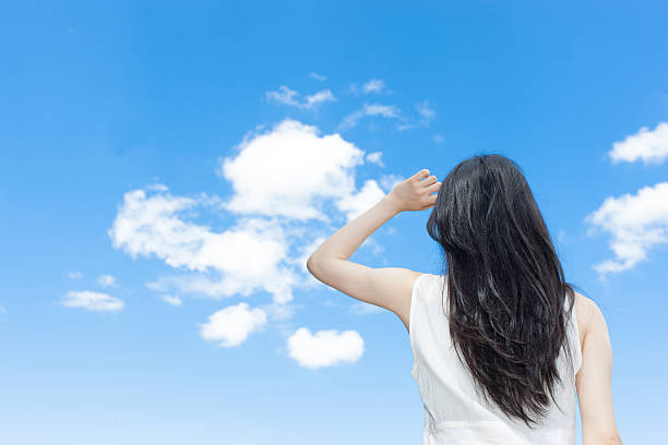 istock Japanese woman standing under a blue sky 611170770