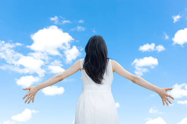 istock Japanese woman standing under a blue sky 611170920