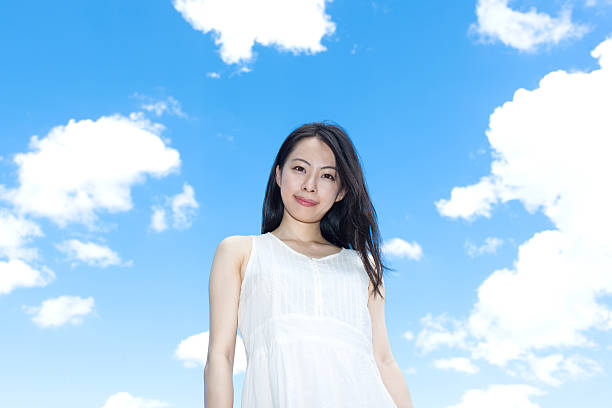 istock Japanese woman standing under a blue sky 611170976