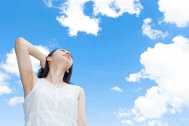 istock Japanese woman standing under a blue sky 611171048