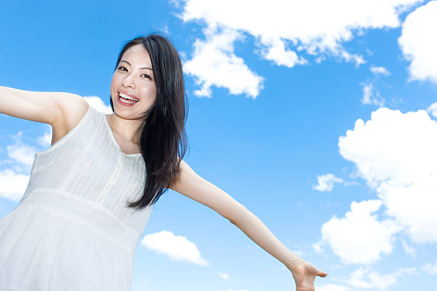istock Japanese woman standing under a blue sky 611171122
