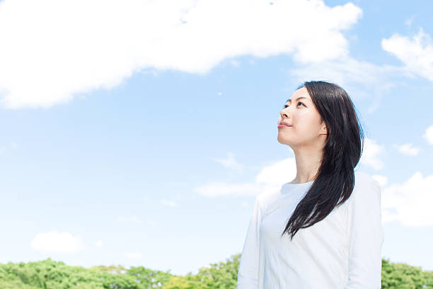 istock Japanese woman standing under a blue sky 611171332