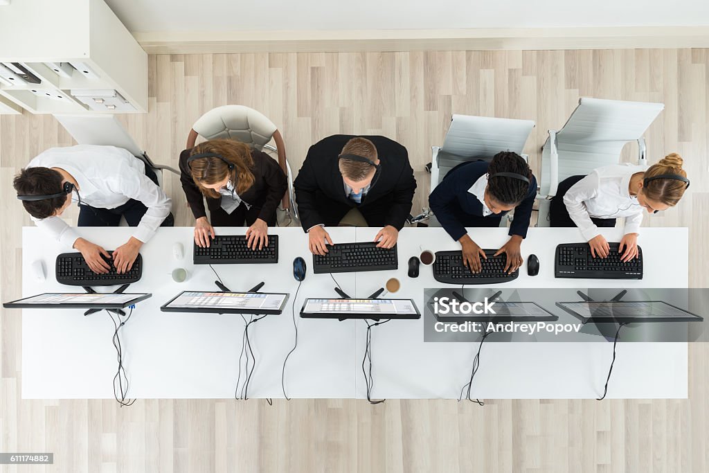 Call Center Operators Working In Office High Angle View Of Call Center Operators Working On Computers In Office Call Center Stock Photo