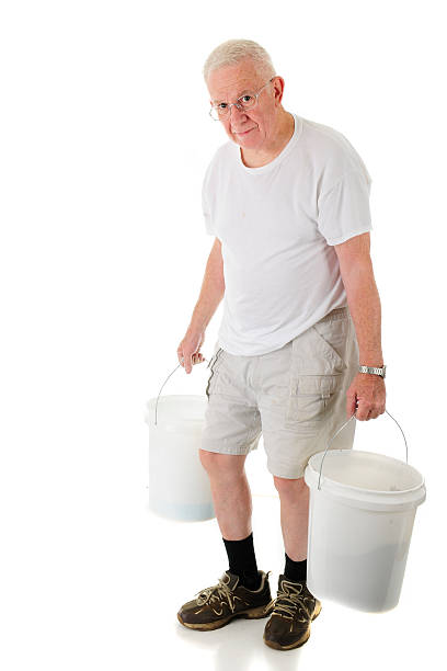 istock Senior Man Hunched Carrying  Buckets 611175164
