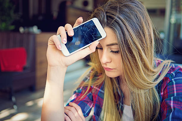 Broken mobile phone Young girl is devastated after her mobile phone is fall down. breaking stock pictures, royalty-free photos & images