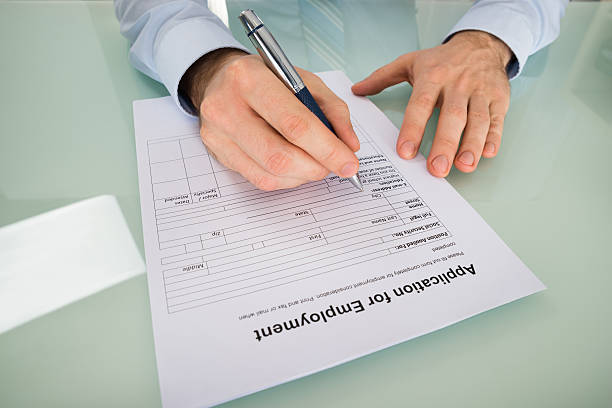 istock Person Hand Filling Application For Employment Form 611177018