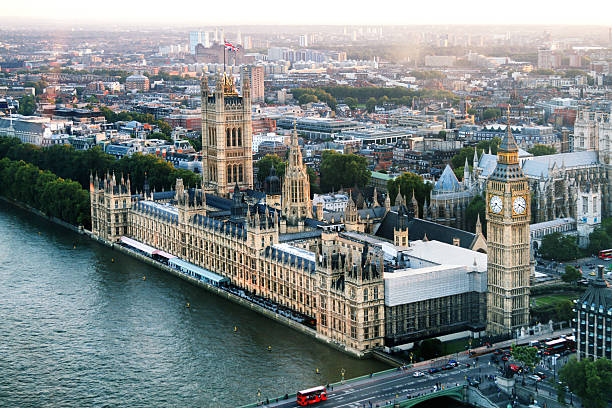 Big Ben and Houses of Parliament On River Thames, Dusk Aerial view of the the Elizabeth Tower which contains the bell Big Ben and the Houses of Parliament for the UK along the Thames River at dusk houses of parliament london stock pictures, royalty-free photos & images
