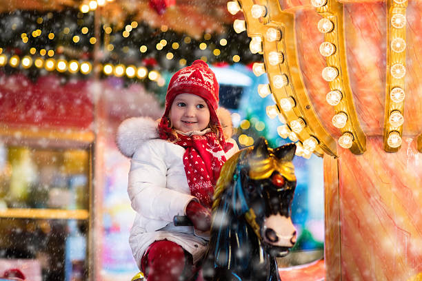 istock Little child riding carousel on Christmas market 611177764