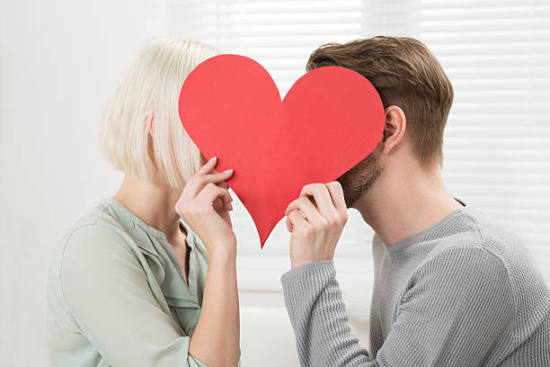 istock Young Couple Kissing Behind Heart Shape 611178820
