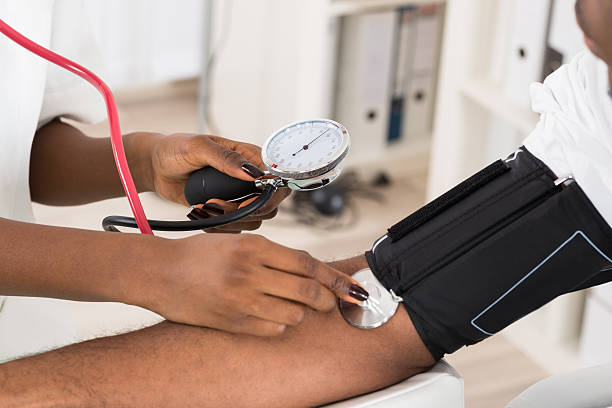 Doctor Measuring Patients Blood Pressure Close-up Of Doctor Measuring Patients Blood Pressure With Stethoscope hypertensive photos stock pictures, royalty-free photos & images