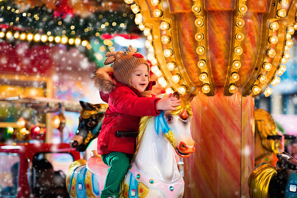 детская карусель на рождественском рынке - аттракцион карусель стоковые фото и изображения