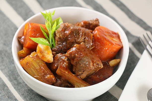 istock Stewed beef with carrot, garlic and herbs in white bowl 611180752
