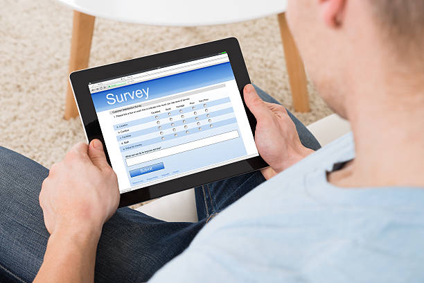 istock Man Filling Survey Form Online On Digital Tablet At Home 611180776